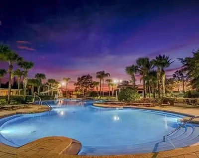 a large swimming pool in a park with palm trees at Themed Villa with Private Pool, Game Room, Resort Amenities, BBQ in Orlando