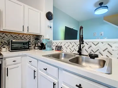 a kitchen with a sink and a microwave at 3BR Family-Friendly Town Home Near Disney in Orlando