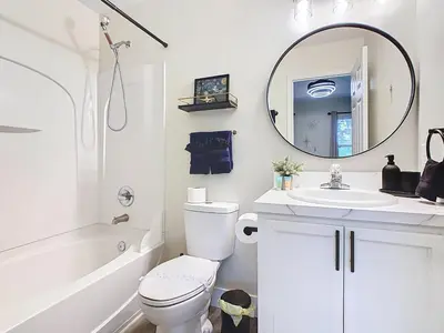 a bathroom with a toilet and a sink and a mirror at 3BR Family-Friendly Town Home Near Disney in Orlando