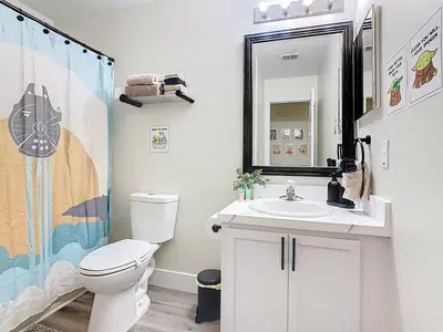 a bathroom with a toilet and a sink and a mirror at 3BR Family-Friendly Town Home Near Disney in Orlando