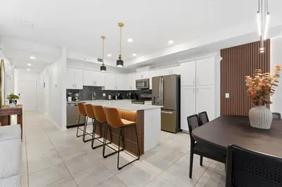 a kitchen with white cabinets and a table and chairs at 207 Storey Lake 6 Guests 2 BDRS near clubhose in Kissimmee