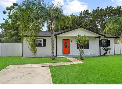 a house with a palm tree in a yard at Spacious Casselberry Home Near Attractions in Orlando