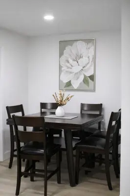 a dining room table with chairs and a vase with a flower at Spacious Casselberry Home Near Attractions in Orlando