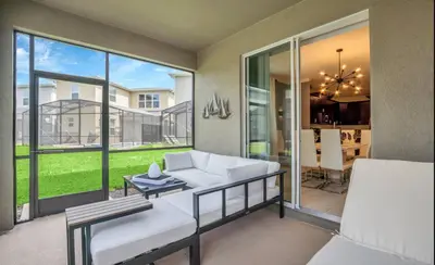 a living room with a white couch and a large window at Pool & BBQ | Disney-Themed Cozy 6BD | Near Disney in Kissimmee