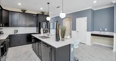 a kitchen with black cabinets and a white counter top at Pool & BBQ | Disney-Themed Cozy 6BD | Near Disney in Kissimmee