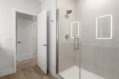 a bathroom with a shower with a glass door at A Magical and Cozy Family Getaway 3BR Home Near Disney Studios in Orlando