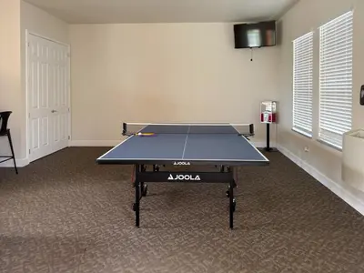 a ping pong table in the middle of a room at A Magical and Cozy Family Getaway 3BR Home Near Disney Studios in Orlando