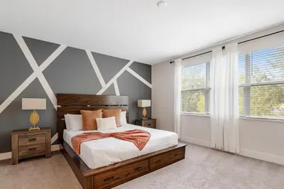 a bedroom with a large bed and two windows at A Magical and Cozy Family Getaway 3BR Home Near Disney Studios in Orlando