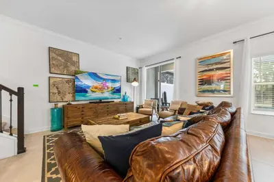 a living room with a brown leather couch at South-Facing Pool 5BR Storey Lake Lazy River 2437 in Kissimmee