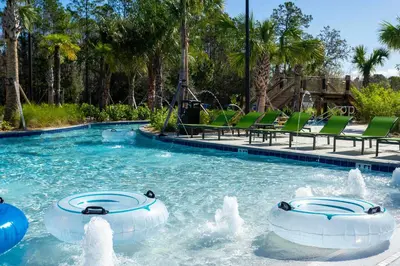 a swimming pool with two water fountains in a resort at South-Facing Pool 5BR Storey Lake Lazy River 2437 in Kissimmee
