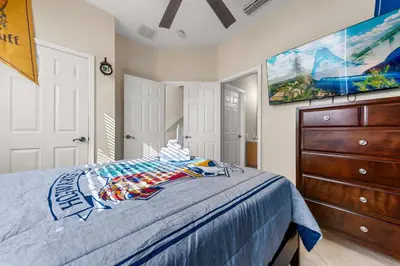 a bedroom with a bed with a dresser and a painting at Private Pool 3BR Resort Villa near Disney in Kissimmee