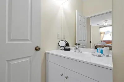 a white bathroom with a sink and a mirror at 4BR Luxury Villa Private Pool & Slide Disney in Kissimmee