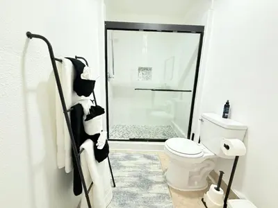 a white bathroom with a toilet and a shower at Family Pool Home |Close to Disney/Universal/Epic in Kissimmee