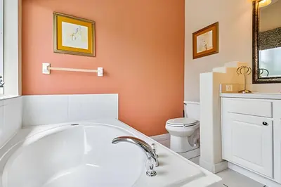a bathroom with a white tub and a toilet at Casa aconchegante em Glenbrook perto da Disney in Orlando