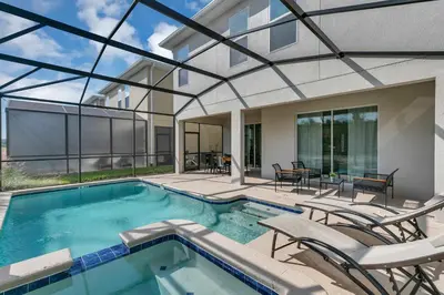 a swimming pool with chairs and a house at Classy 6BR Home with Private Pool in Kissimmee