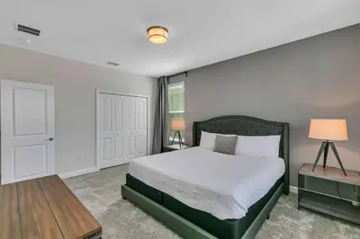 a bedroom with a large bed and a table at Classy 6BR Home with Private Pool in Kissimmee