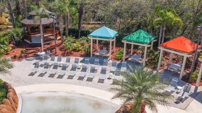 an aerial view of a pool with chairs and a gazebo at Restpool vibes, Nest tree-ish Retreat- NxtDisney in Kissimmee