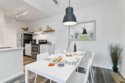 a white kitchen with a white table and chairs at Pause Discover something that nourishes your soul in Kissimmee