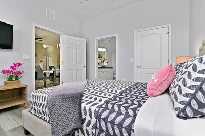a bedroom with a black and white bed with pink pillows at Sunset every single day ReserveView 4BRElevator in Kissimmee