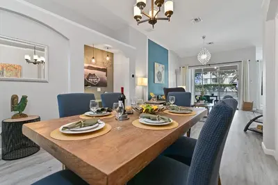 a dining room and living room with a table and chairs at Finest renovated w Pool, Game rm, 4 Mi to Disney in Kissimmee