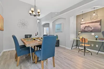 a dining room and living room with a table and chairs at Finest renovated w Pool, Game rm, 4 Mi to Disney in Kissimmee