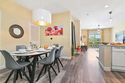 a dining room and kitchen with a table and chairs at SPECTACULAR CONDO only 4 Miles to Disney! in Kissimmee