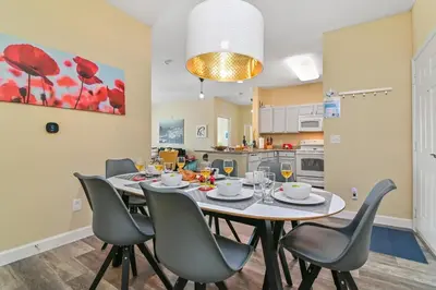 a dining room and kitchen with a table and chairs at SPECTACULAR CONDO only 4 Miles to Disney! in Kissimmee