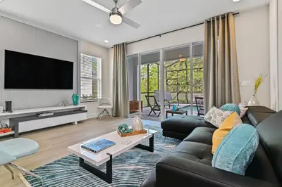 a living room with a couch and a tv at Look Out over Nature - Unique FRESH Corner Home in Orlando