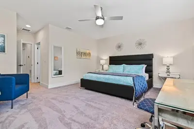 a bedroom with a bed and a blue chair at Look Out over Nature - Unique FRESH Corner Home in Orlando