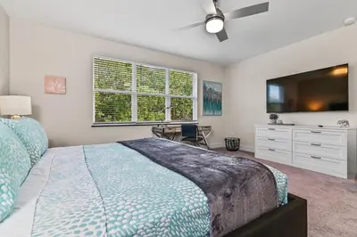 a bedroom with a bed and a tv and a desk at Look Out over Nature - Unique FRESH Corner Home in Orlando