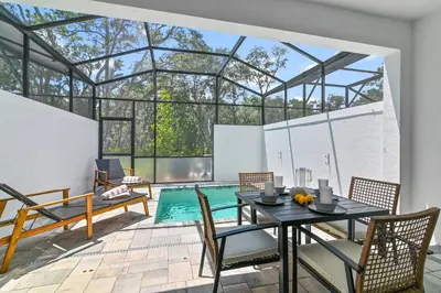 a room with a table and chairs and a swimming pool at Oasis NEW Townhome Splash Pool Nature-Infused in Orlando
