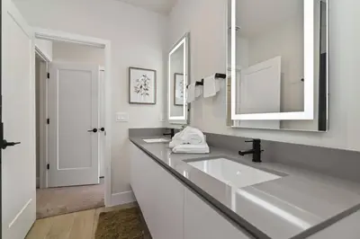 a white bathroom with two sinks and a mirror at Oasis NEW Townhome Splash Pool Nature-Infused in Orlando