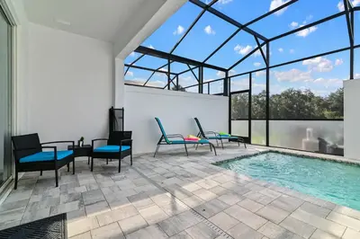 an indoor swimming pool with chairs and a table and a tablektop at Discover Your Escape - NEW house wPrivate Pool in Orlando