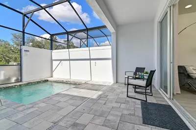 an indoor pool with a table and a chair at Happiness is a destination ! - NEW house with pool in Orlando