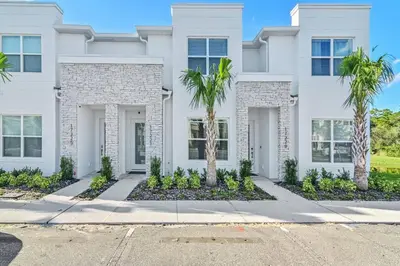 a white house with palm trees in front of it at Happiness is a destination ! - NEW house with pool in Orlando