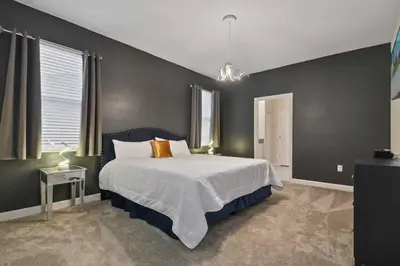 a bedroom with a bed and a black wall at Casa 9Q no Storey Lake c/ Piscina Cinema e Games in Kissimmee