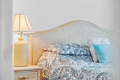 a bed with pillows and a lamp on a night stand at Windsor Palms 3BR FUN Retreat, Pool, Near Disney in Kissimmee