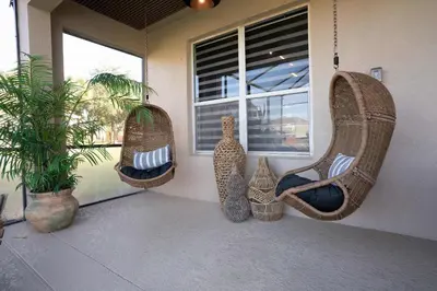 a porch with two swing chairs and a window at New Modern STAR WARS Villa Only 3 Miles 2 Disney w VR's in Kissimmee