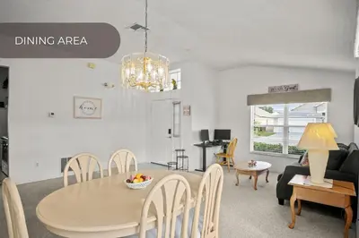 a dining room and living room with a table and chairs at Cozy 3BR Family Home Minutes from Disney in Kissimmee