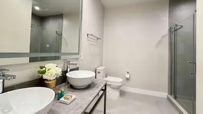 a bathroom with a sink and a toilet and a mirror at Brand New Home with 4 En-Suites, near Disney in Kissimmee