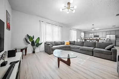 a living room with a couch and a table at Amazing 08 BdrmsSleeps 14Pool in Kissimmee