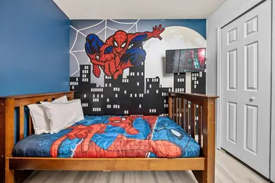 a bedroom with a spider man mural on the wall at Amazing 08 BdrmsSleeps 14Pool in Kissimmee