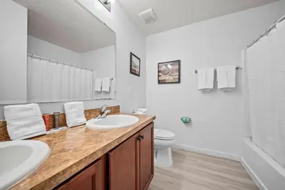 a white bathroom with two sinks and a toilet at Amazing 08 BdrmsSleeps 14Pool in Kissimmee