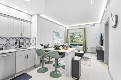 a kitchen with a table and green chairs in it at 1 bedroom apartment near Disney and Universal in Orlando