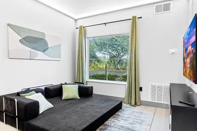 a living room with a couch and a window at 1 bedroom apartment near Disney and Universal in Orlando