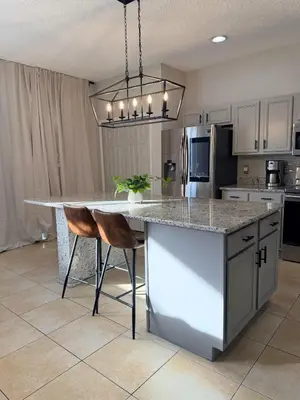 a kitchen with a large kitchen island with two chairs at 7 Bd/ 5.5 Ba- Terra Verde Resort -Near Disney in Kissimmee