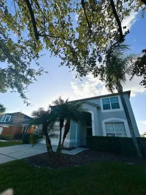 a house with a palm tree in front of it at 7 Bd/ 5.5 Ba- Terra Verde Resort -Near Disney in Kissimmee