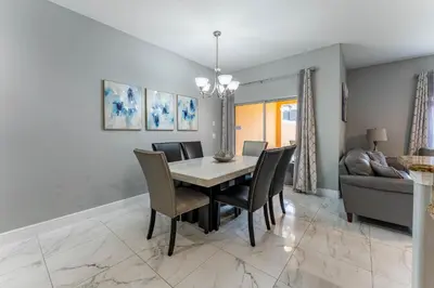 a dining room with a table and chairs and a couch at Four Bedroom Private Pool Townhome, near Disney in Kissimmee