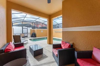 a living room with two chairs and a swimming pool at Four Bedroom Private Pool Townhome, near Disney in Kissimmee