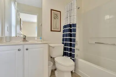 a bathroom with a toilet and a sink and a tub at Spacious 5-Bedroom 4-Bath Pool & Spa Villa in Emerald Island Resort in Kissimmee